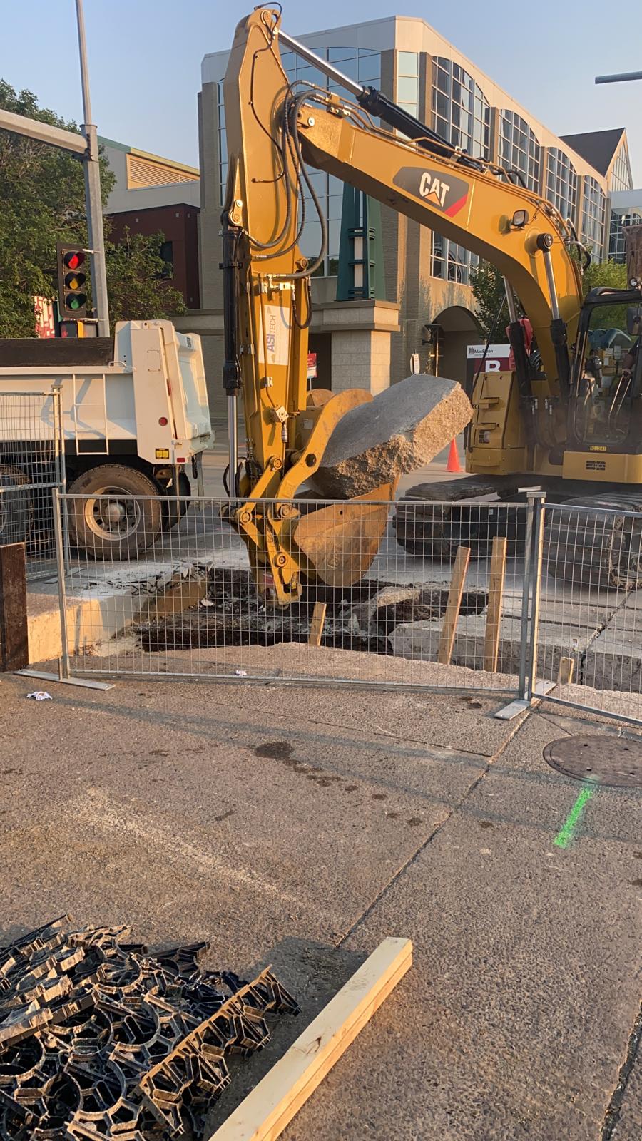 ASI Tech CAT excavator removing concrete in downtown intersection